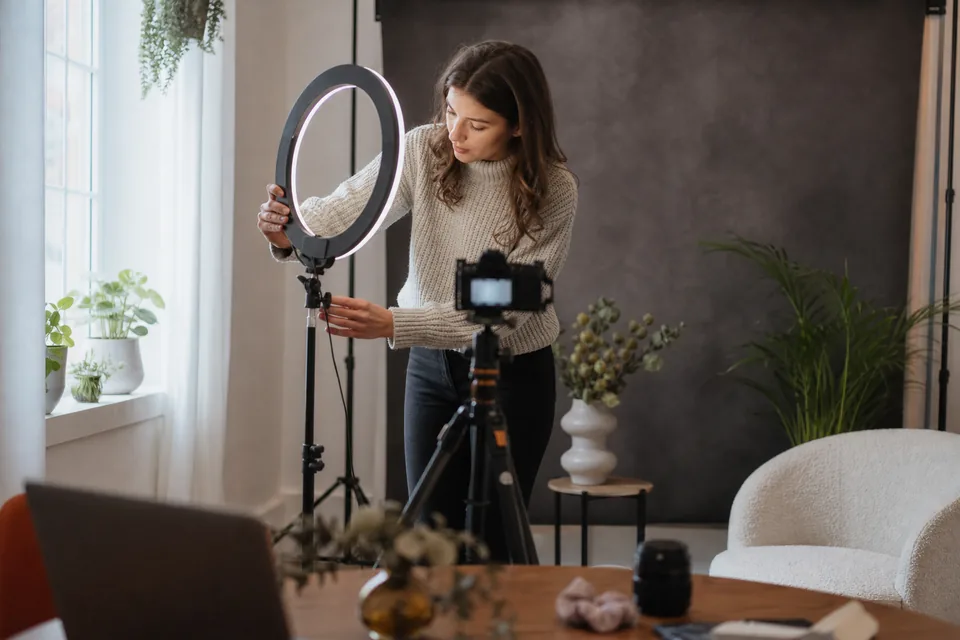 Content creator setting up a ring light and camera at home